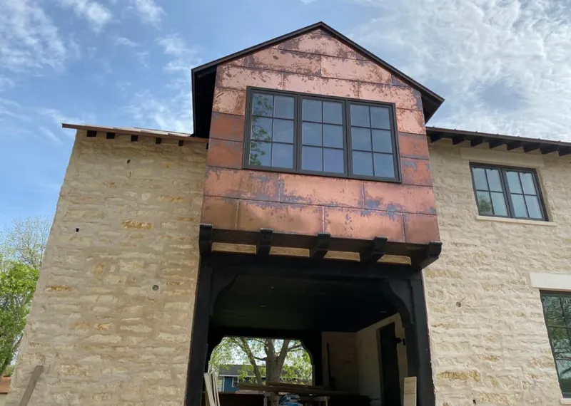 Copper metal panel facade on a stone building for Roof Repair in Overland Park
